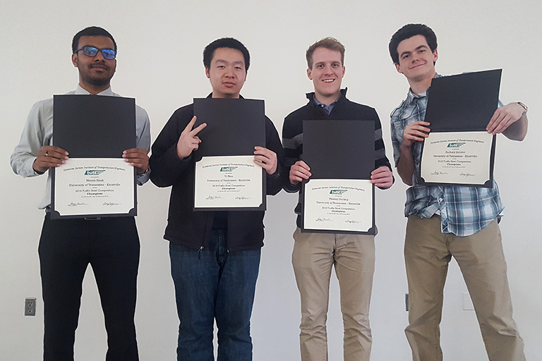 Nitesh Shah, Yi Wen, Wesley Darling, and Zachary Jerome hold winning certificates.