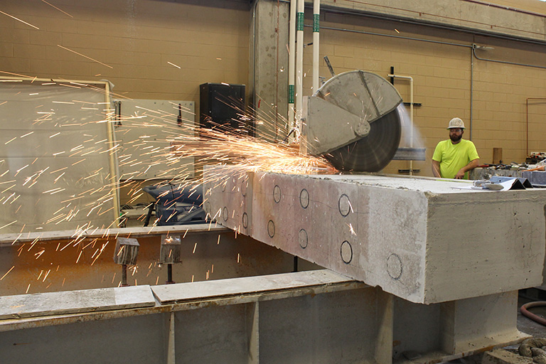 A large saw cuts through a concrete block.