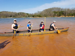 UT students pose inside concrete canoe