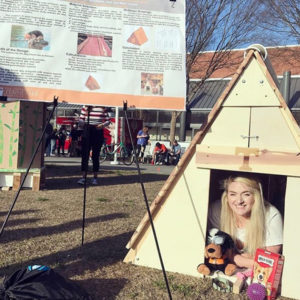Student inside UT's Sustainability Solutions doghouse entry