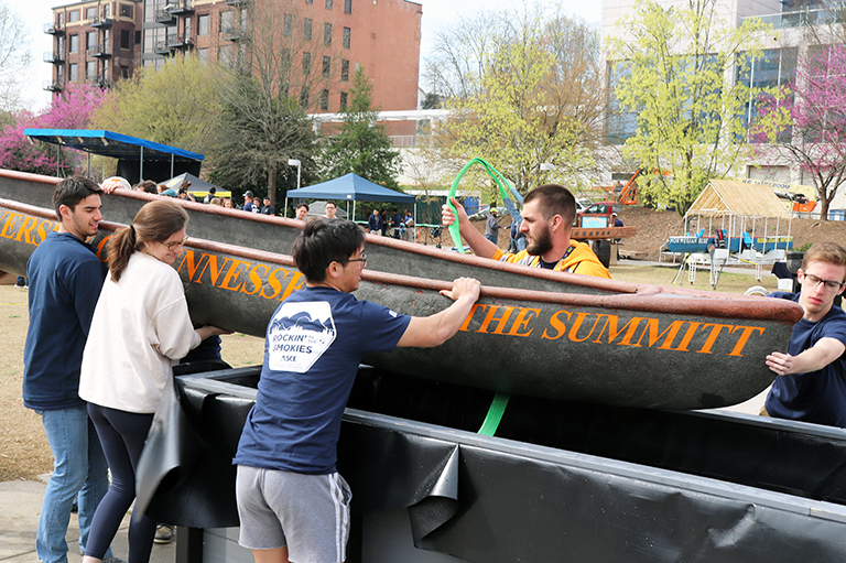 Students ease UT’s Concrete Canoe into the Swamp Test.
