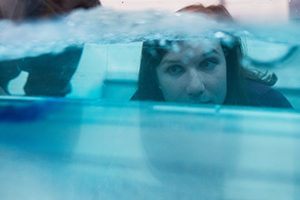 Woman looking in dyed water.