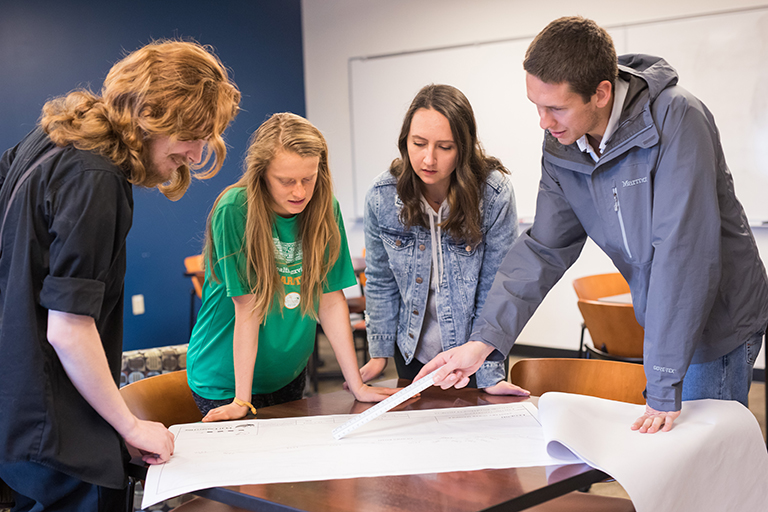 The Senior Design team looks over blueprints.