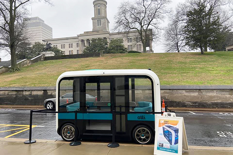 Small autonomous bus sits in a parking lot in Nashville.