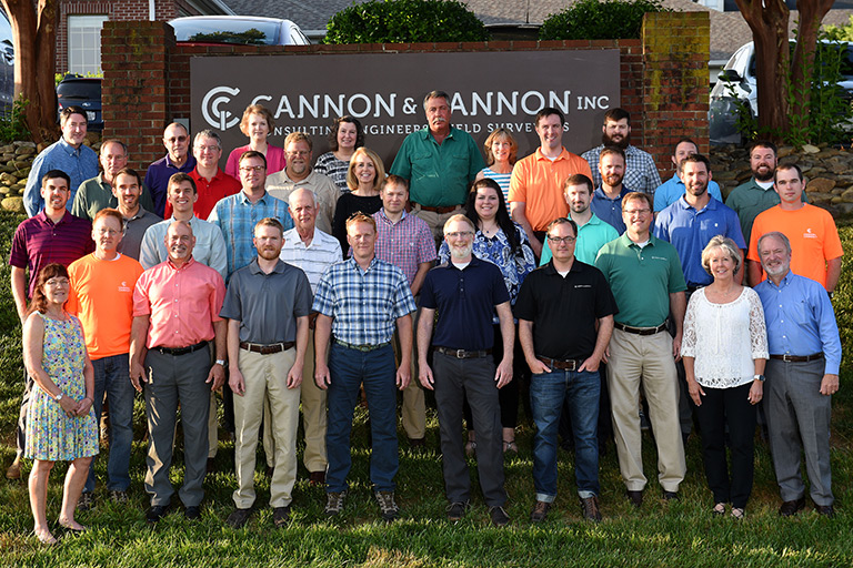Group photo of Cannon & Cannon employees in front of company sign.