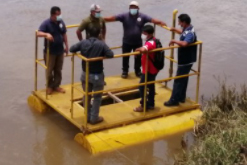 Several people stand on a small barge in Panama.