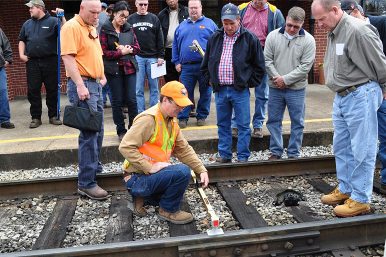 David Clarke kneels on a railroad track.