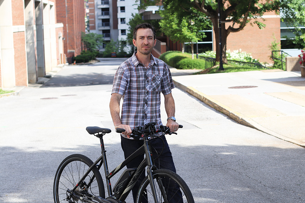 Chris Cherry stands beside an e-bike.