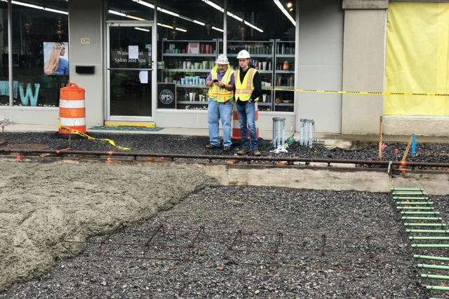 Doug and Charles Blalock discuss a project in front of a business.