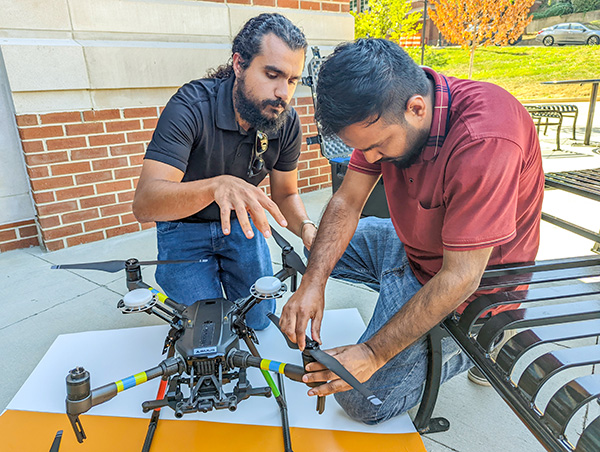 A graduate student and professor work on the drone they are using to capture thermal images