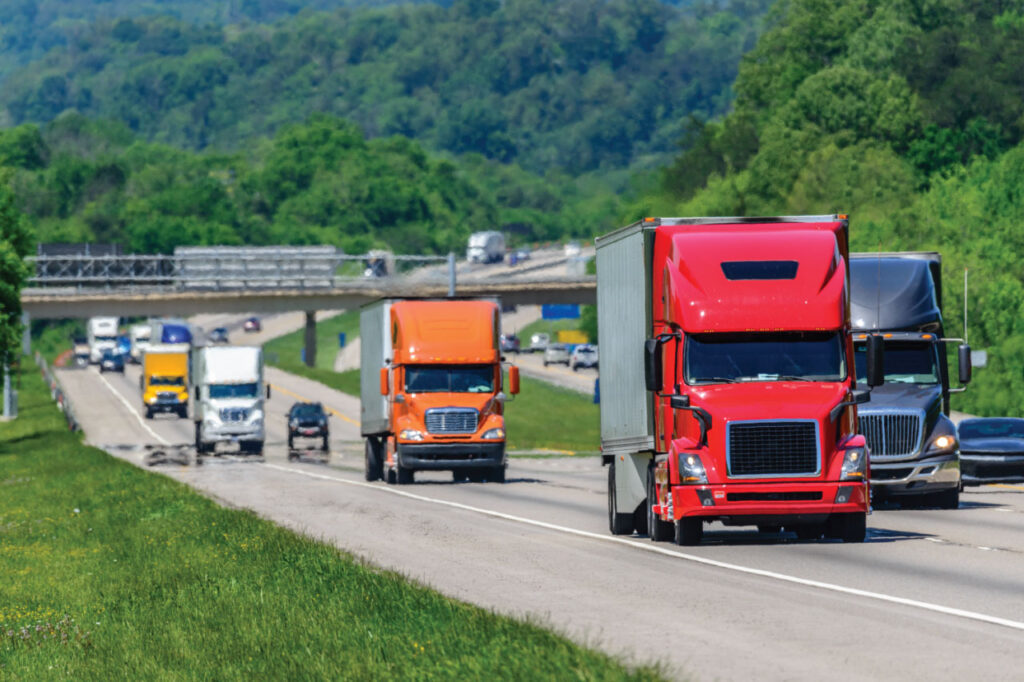Multiple semi-trucks traveling on a Tennessee interstate.