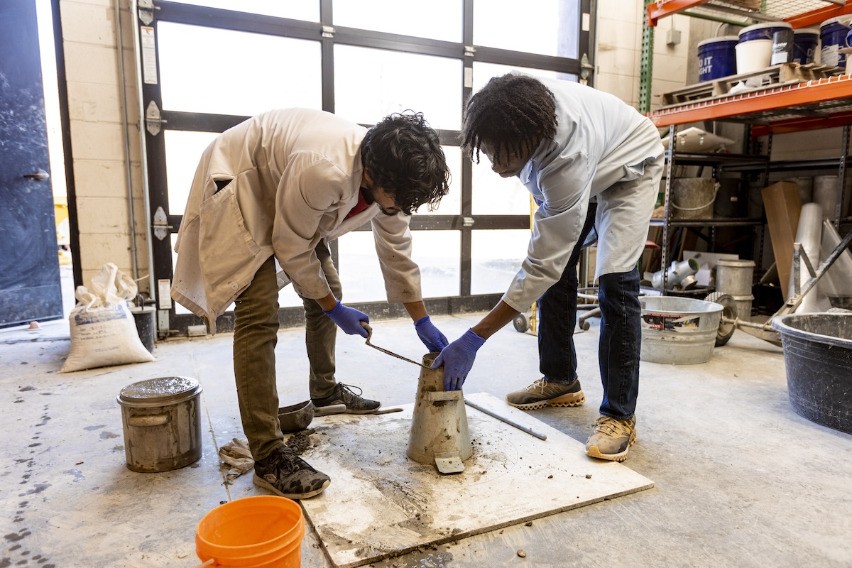 Sazzadul Saykat and Caleb Napper creating a concrete mixture in the lab
