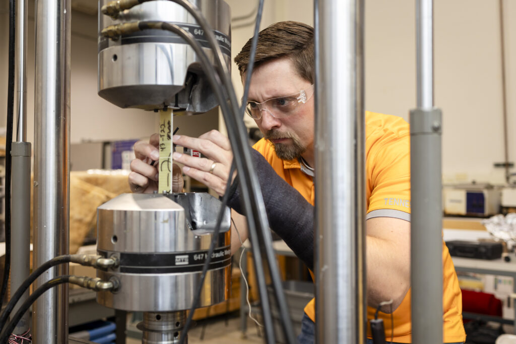 Zack Arwood setting up a machine to run tests in a lab