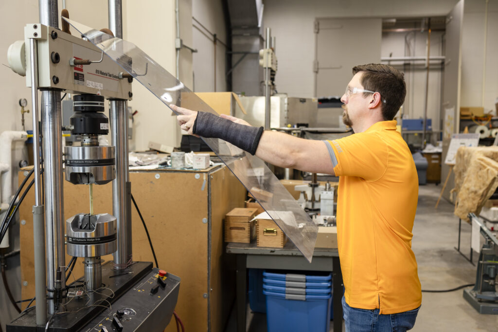 Zack Arwood using plexiglass to set up a machine to run tests