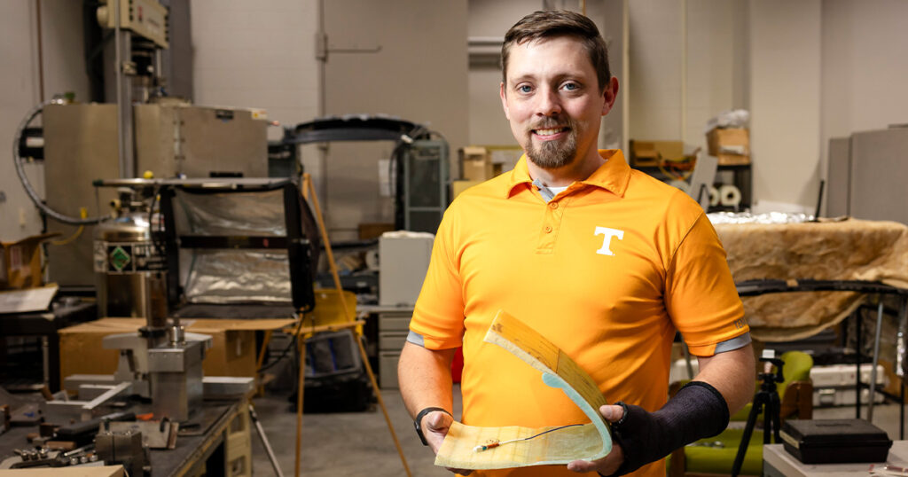 Zack Arwood standing in a lab wearing an orange UT shirt