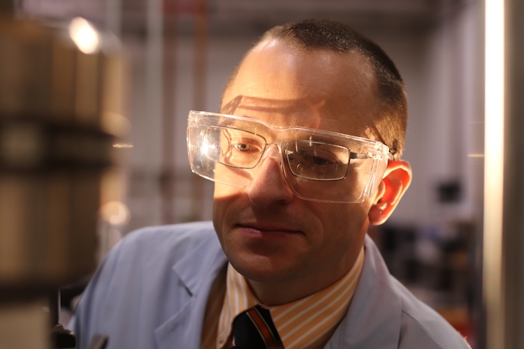 Timothy Truster wearing a coat and safety glasses in the lab