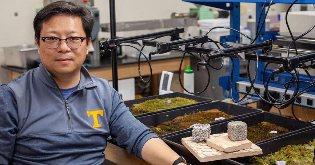 Nick Zhou sitting next to his PhantoM tiles and moss experiments