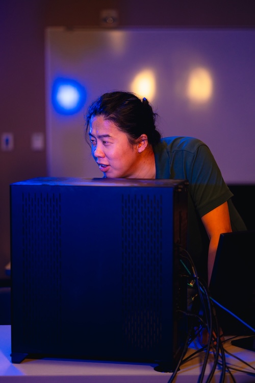 Haochen Li standing in front of a computer monitor