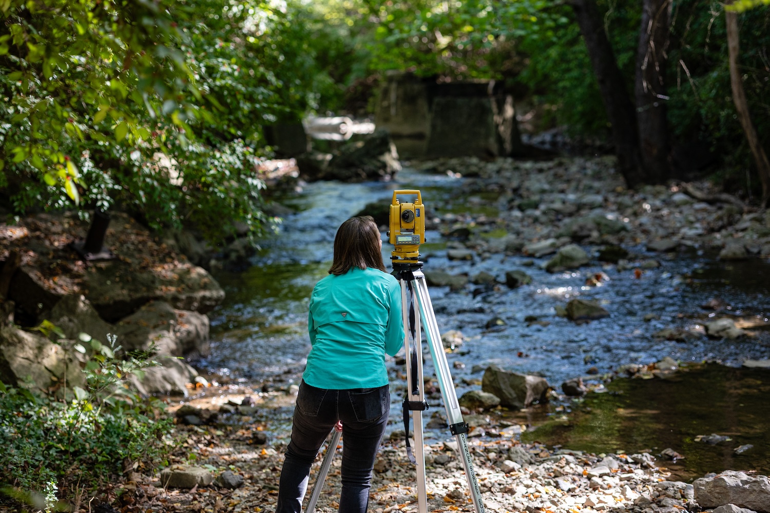 Ceara Parks Oliver setting up a tool by a creek
