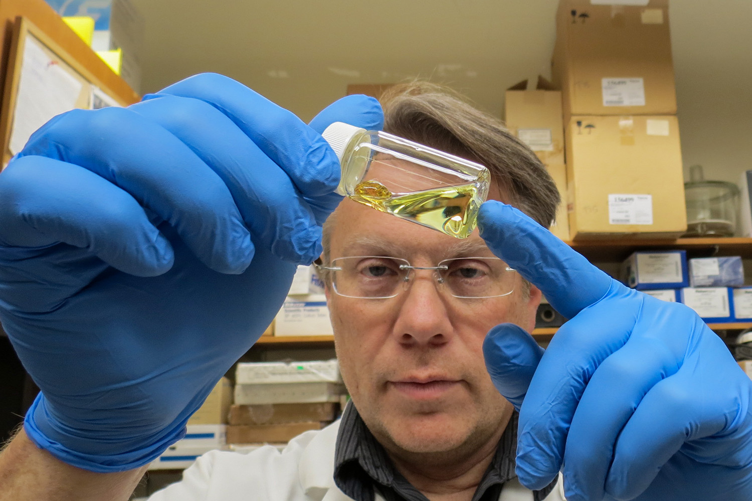 Larry Millet looking at something in a bottle